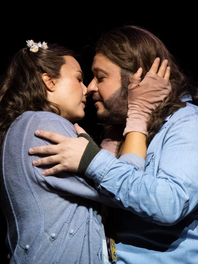 Mimí och Rodolfo omfamnar varandra, på väg att kyssas.