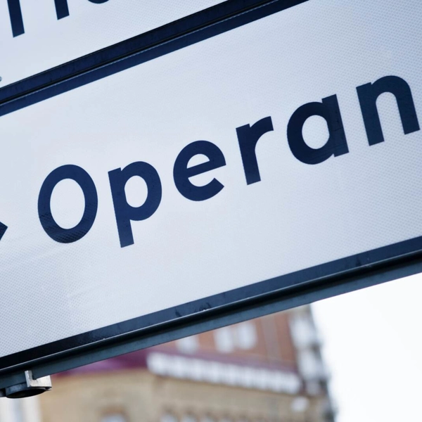 Närbild av en stadsgatuskylt som visar en pil som pekar mot "Operan".